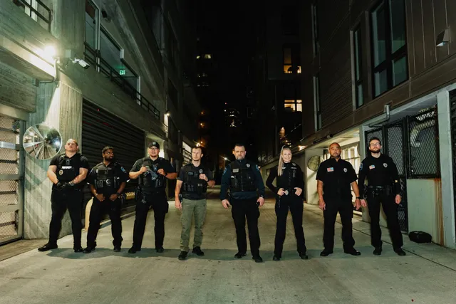 Professional security team standing in formation in an urban alley at night, demonstrating readiness and coordinated protection services.