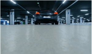 Modern parking garage with surveillance cameras monitoring vehicles for enhanced building security in Northern California ا
